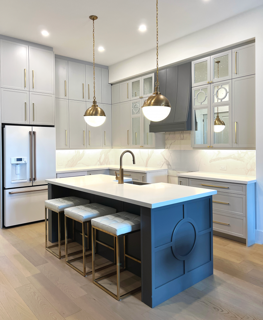 Two-toned grey kitchen, island overlay panels, gold hardware, glass doors in kitchen